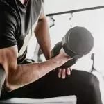 Un homme réalisant un curl biceps. 