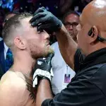 Conor McGregor recevant de la vaseline sur son visage avant de monter dans l'octogone. 