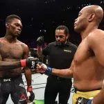 Israel Adesanya et Anderson Silva dans l'octogone lors de leur combat à l'UFC en 2019. 