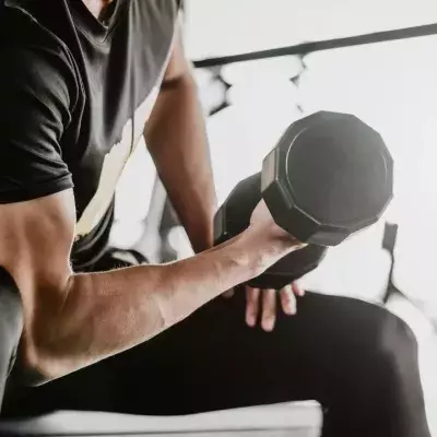 Un homme réalisant un curl biceps. 