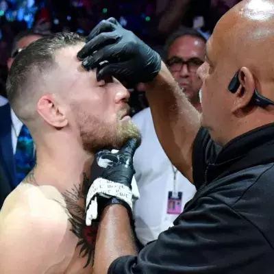 Conor McGregor recevant de la vaseline sur son visage avant de monter dans l'octogone. 
